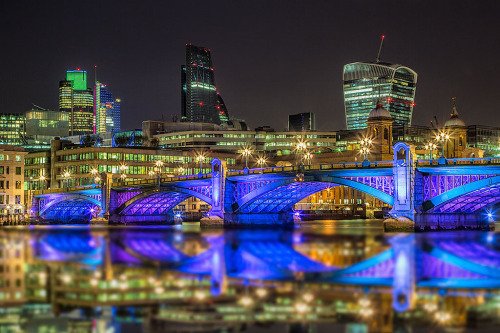 London Bridge and Walkie Talkie Building Reflected in River Thames at night in Blue Lights